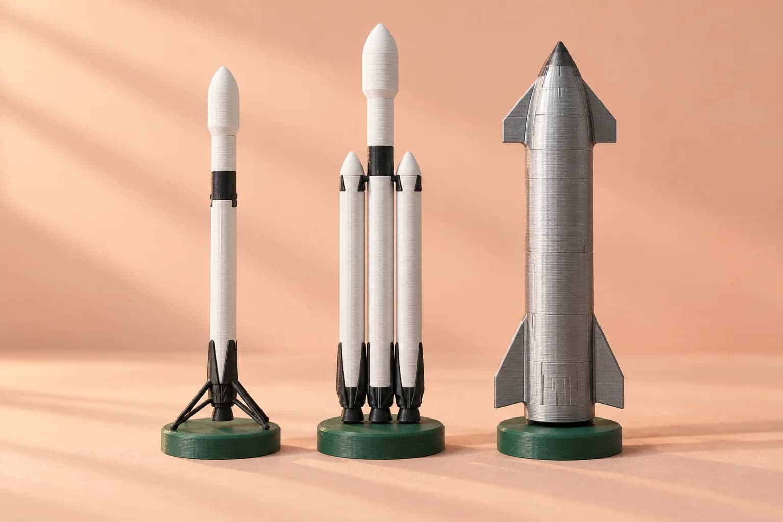 AI concept of three 3D-printed desk rockets: a white and black reusable booster, a triple-core heavy rocket, and a silver starship